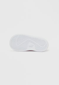 Σόλα λευκού αθλητικού παπουτσιού Puma, εμφανιζόμενη από κάτω, με μοτίβο τρακτερωτού ζιγκ-ζαγκ και το λογότυπο Puma στο κέντρο.