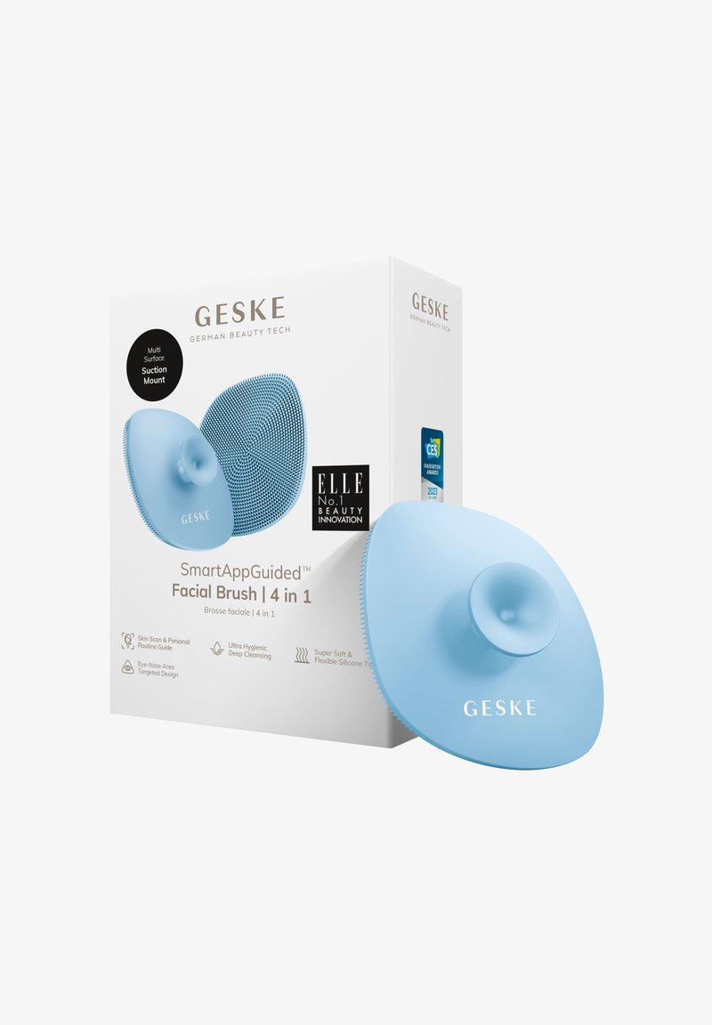 Helle blaue Silikon-Gesichts Bürste mit Saugnapf. Texturierte Oberflächengestaltung. Die Verpackung zeigt Produktdetails und Auszeichnungen.