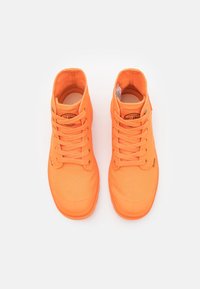 Zapatillas altas de lona de color naranja brillante con cordones a juego, punta de goma y un parche de logo redondo en el lateral.