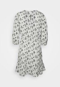 Vestido branco com padrão floral preto e bolinhas. Apresenta mangas bufantes, cintura com cordão ajustável e uma barra rodada. Detalhe nas costas em forma de buraco de chave.