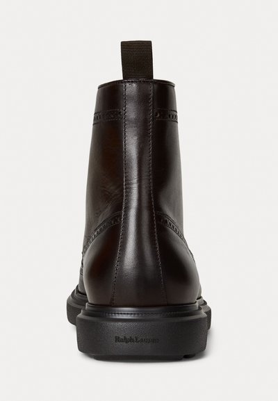 Pruunist nahast pahkluu saapad, millel on sile pind, õmblustooted ja tõmbluku kinnituse tagaküljel. Must kummist tald, millel on "Ralph Lauren" brändimine.