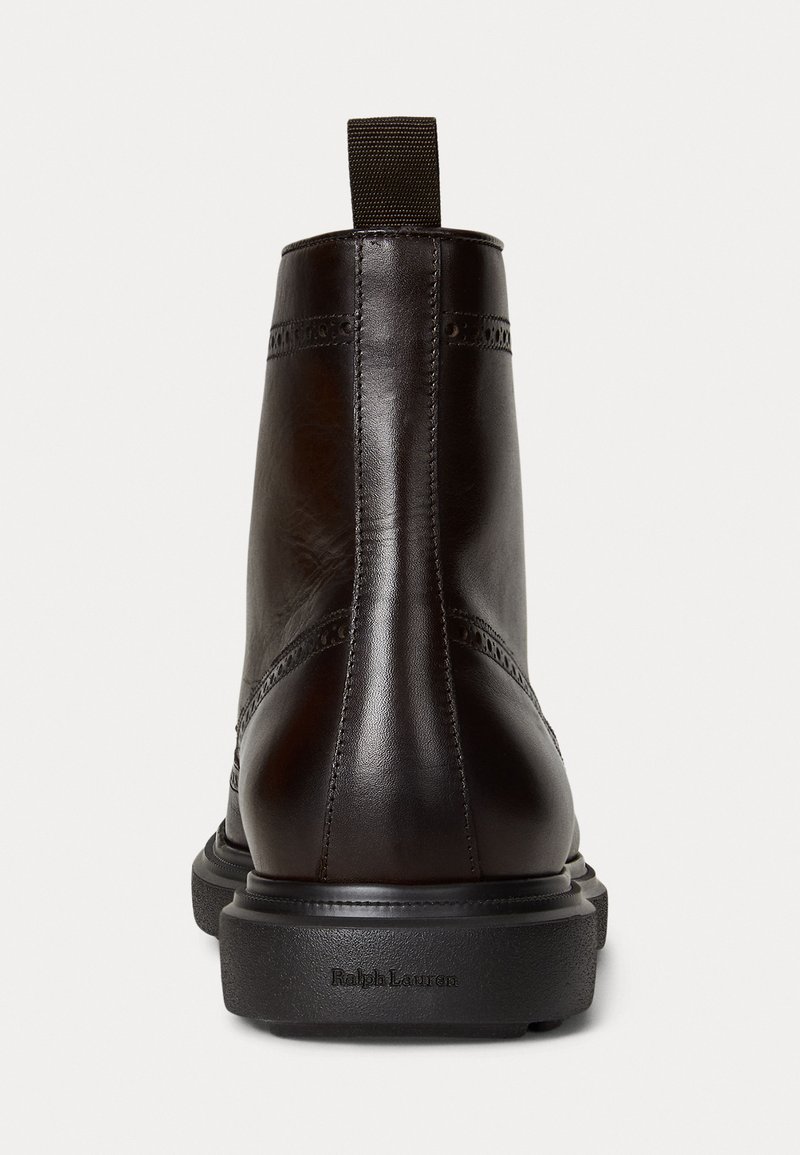 Botín de cuero marrón hasta el tobillo con textura suave, detalles de costura y una lengüeta en la parte posterior. La suela de goma negra presenta la marca "Ralph Lauren".