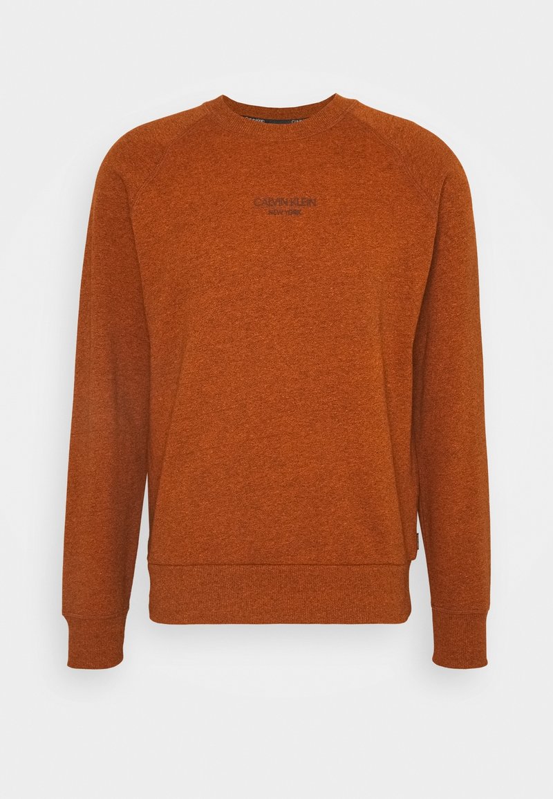 Felpa arancione realizzata in tessuto testurizzato. Presenta un colletto rotondo, lunghe maniche raglan e un piccolo logo sul petto.