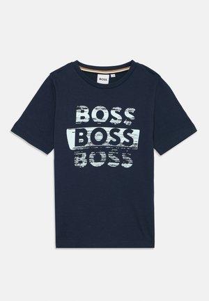 T-shirt en coton bleu marine avec col rond et manches courtes, arborant un texte "BOSS" usé en blanc et bleu clair sur le devant.