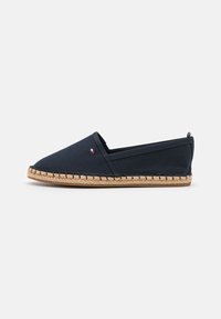 Espadrille in tela navale con punta affusolata, suola in corda di juta e dettagli impunturati. Presenta un piccolo accento di marca vicino al tallone.
