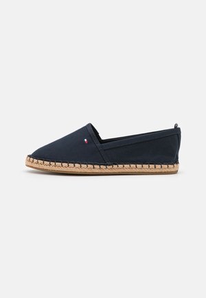 Marineblå lærred espadrille med spids tå, jute reb sål og syet detalje. Har et lille brand accent nær hælen.