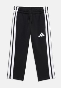Crne trenirke s bijelim bočnim trakama i Adidas logotipom na donjem dijelu nogavice, s podesivim pojasom.