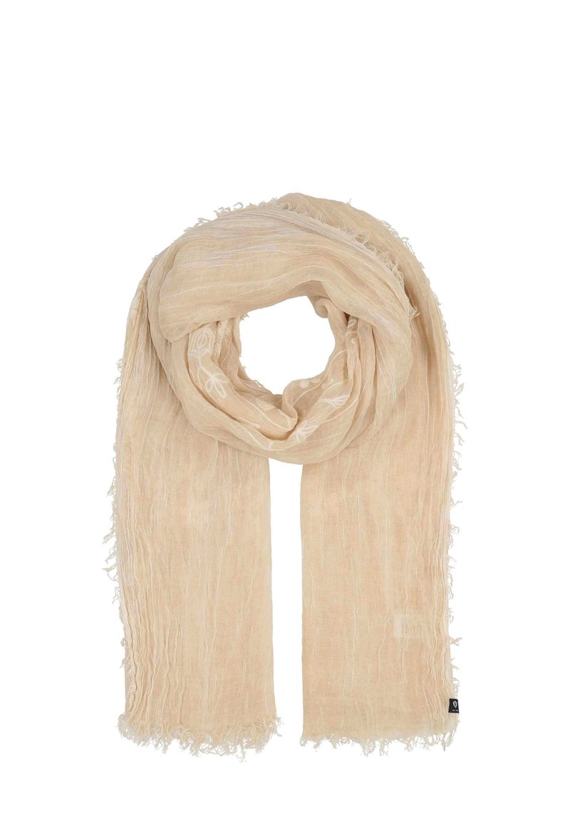 Beige vävd scarf med en texturerad yta, fransade kanter och subtil dekorativ sömnad längs ena sidan.