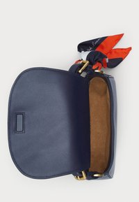 Navy leather handbag with a soft texture and a rounded flap. Interior lined in brown suede. Features a colorful silk scarf tied at the handle.