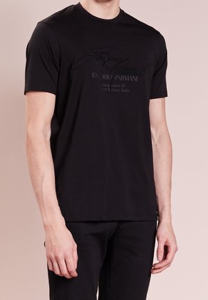 Czarna bawełniana koszulka z okrągłym dekoltem, krótkimi rękawami i tłoczonym napisem z przodu. Minimalistyczny design i gładka tekstura.