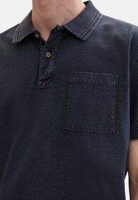 Tmavě modrá polo košile ze směsi bavlny, s texturovaným límcem, dvouknoflíkovou légou a náprsní kapsou. Měkká, hladká textura.