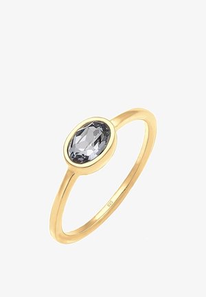 Bague en or avec une fine monture tenant une seule pierre précieuse claire en forme ovale, facettée, sertie en chaton.