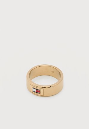 Goudkleurige textuurring met een rechthoekig embleem van een vlag in rood, wit en blauw op een witte achtergrond.