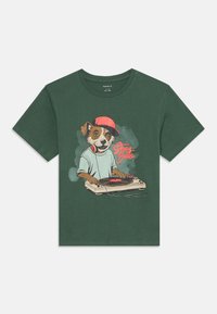 Tumši zaļš T-krekls ar karikatūras suni, kas valkā sarkanu cepuri un austiņas, griežot vinilu uz griežamā galda, uzraksts "Stray Beats".