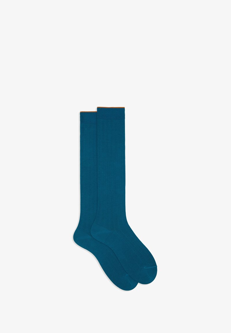 Calze al ginocchio in teal con texture a coste e polsino arancione a contrasto. Realizzate in un materiale morbido, adatte per abbigliamento casual o formale.