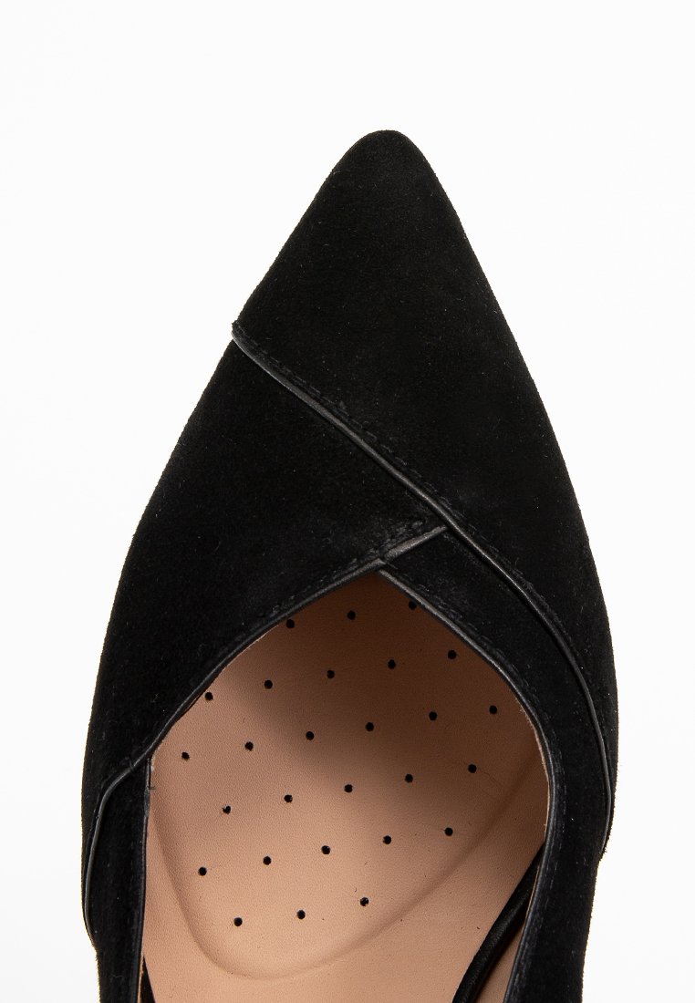 Schwarzer Wildleder-Schuh mit spitzem Zeh und angularer Form, ausgestattet mit einer glatten, tanfarbenen Innensohle mit Perforationen für Atmungsaktivität und Komfort.