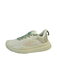 Scarpa sportiva beige chiaro con tomaia in rete, lacci turchesi e suola ammortizzata. Presenta un marchio discreto e dettagli testurizzati sui lati.