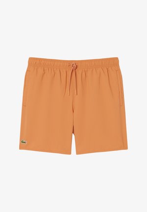 Orange men's swim shorts with elastic waistband, front drawstring, side pockets, and a small green crocodile logo on the left leg.
