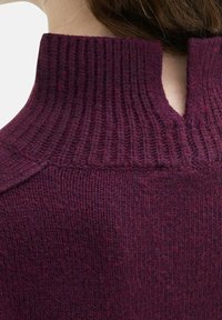 Pull bourgogne avec un col haut à côtes et une découpe en forme de clé au dos. Texture tricotée avec des teintes légèrement variées.