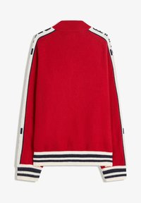 Red knitted cardigan featuring a ribbed collar, striped cuffs and hem, and contrasting white and navy detailing along the sleeves.