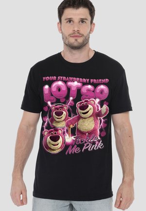 Man wearing black t-shirt with pink cartoon bear "Lotso" characters and text "Your strawberry friend Lotso, Tickle Me Pink."