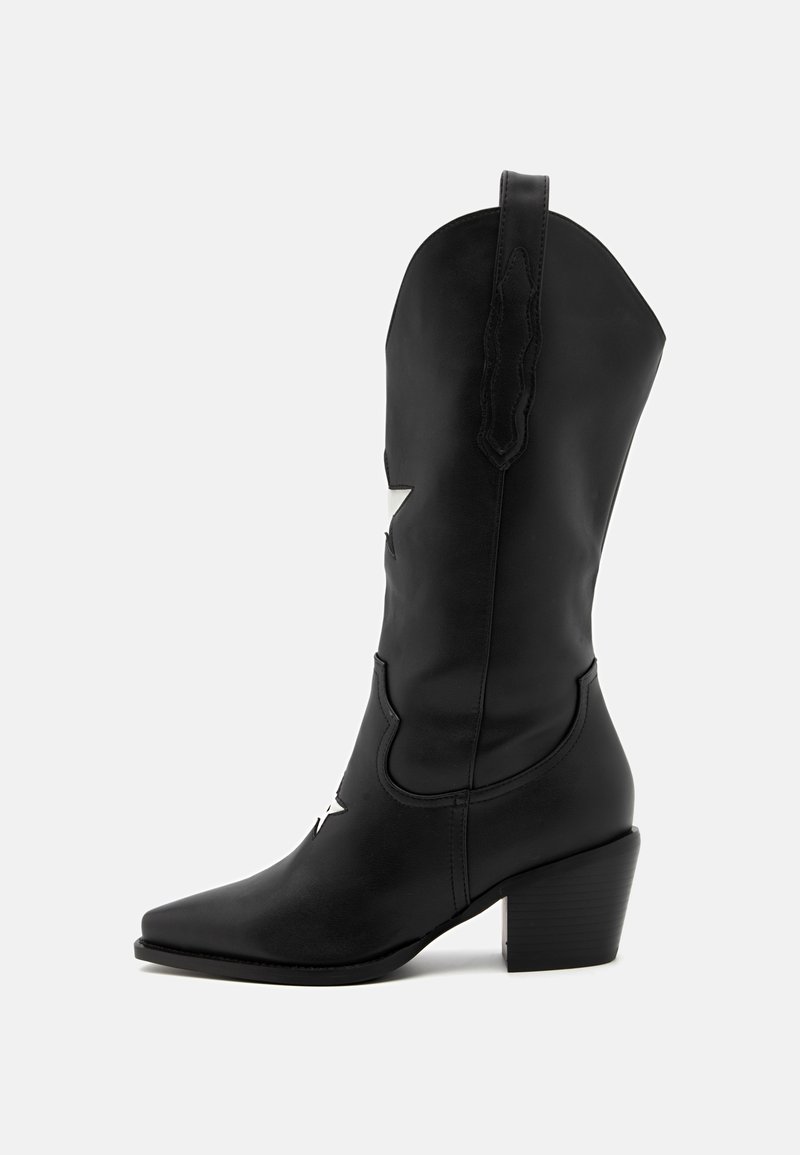 Stivale da cowboy in pelle nera con punta affusolata, altezza a metà polpaccio, accenti a forma di stella argentata e tacco grosso. La cucitura è visibile.