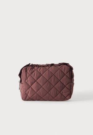Pochette rectangulaire en tissu marron matelassé avec fermeture éclair et léger détail froncé en haut sur fond uni.
