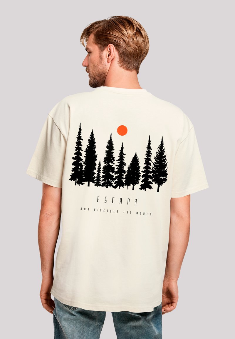 Cream t-shirt featuring a black forest silhouette and an orange sun, with text reading "ESCAPE AND DISCOVER THE WORLD" below the design.