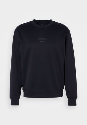 Granatowy sweter crewneck wykonany z miękkiej tkaniny. Posiada subtelne teksturowane logo na środku oraz ściągacze na rękawach i u dołu, zapewniające dobre dopasowanie.