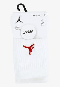 White crew socks in a three-pack, featuring a red embroidered logo. Made from cushioned material, displaying ribbed texture and label details.
