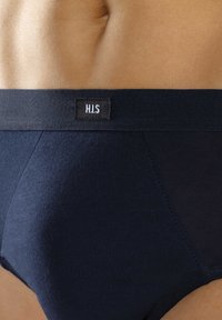 Navy blue men's briefs made of soft fabric with a smooth waistband featuring a black label with "H.I.S." logo.