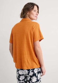 Ontspannen fit korte mouwen overhemd in gestructureerde gebrande oranje stof, met een kraag en een zoom die iets onder de taille valt.
