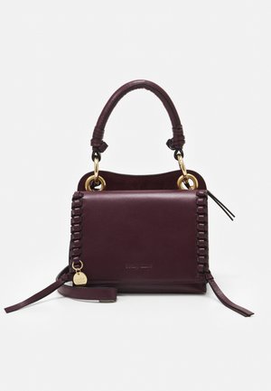 Dunkellila Ledertasche mit geflochtenen Seiten, kurzem Griff mit goldenen Ringen, Frontklappe und einem kleinen runden goldenen Anhänger an einem Riemen.