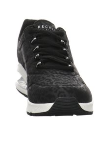 Black athletic shoe with leopard print texture, featuring black laces, a white sole, and branding on the tongue.