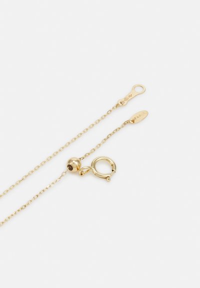 Aranysárga nyaklánc, finom lánccal, kerek záródással és egy kis kerek gyönggyel a zárnál, gravírozott címkével, amely "PÁRIS" feliratot visel.