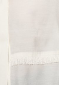 White lightweight fabric with a smooth texture, featuring a fringed edge at the bottom and subtle variations in color throughout.