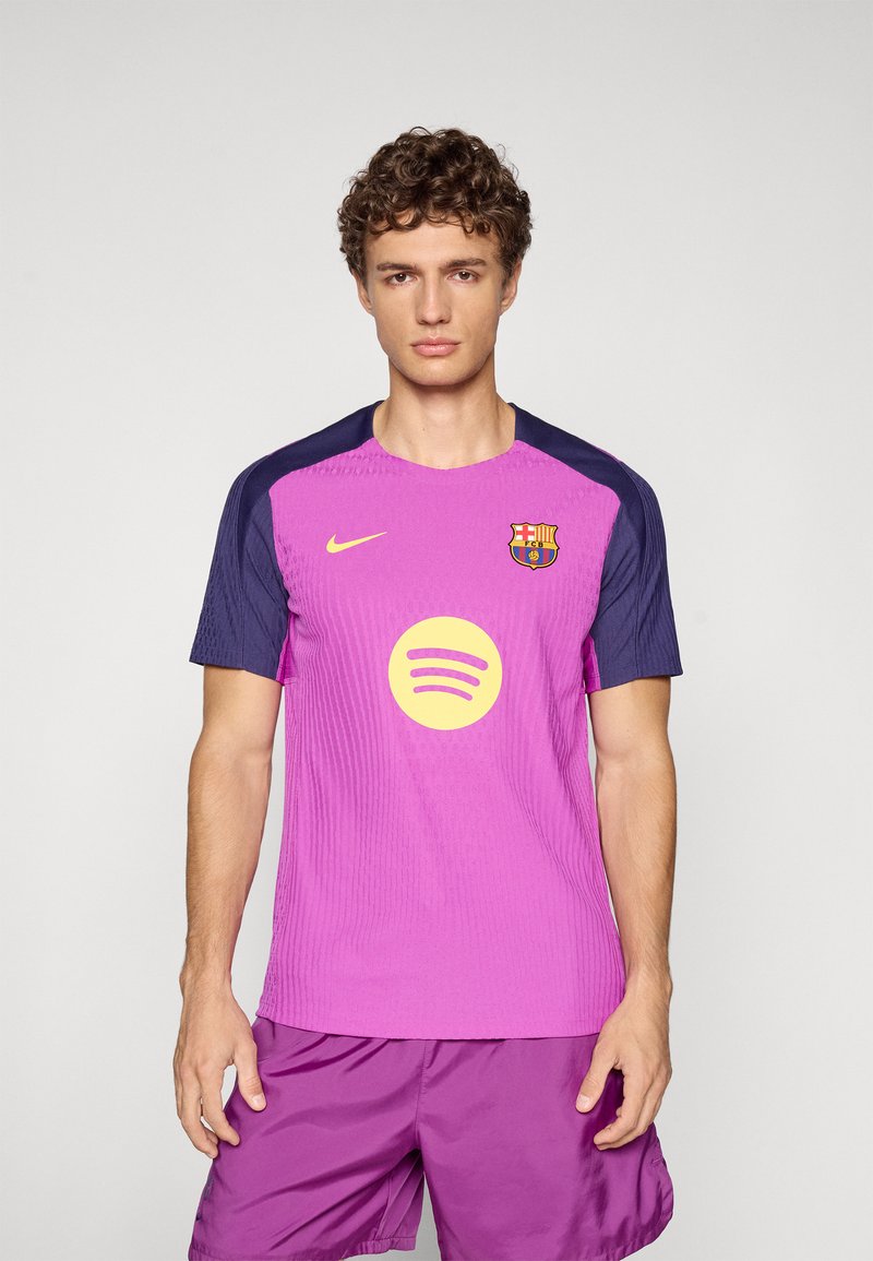 Nogometna majica FC Barcelone Nike, v svetlo roza barvi z temno modrimi rokavi. Ima velik rumen logotip Spotify in grb kluba na prsih.
