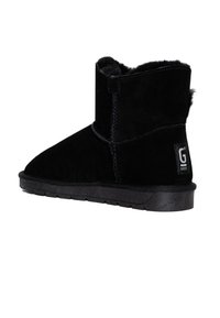 Stivale alla caviglia in suede nero con foderatura in pelliccia sintetica, punta arrotondata e suola in gomma testurizzata. Presenta un'etichetta con logo sul lato.