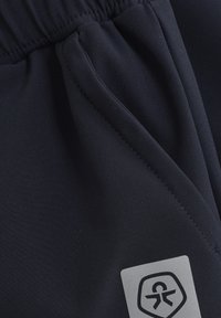 Marineblauwe sportshorts gemaakt van zachte, rekbare stof met een elastische tailleband en zijzak. Voorzien van een logopatch aan de onderkant van de voorkant.