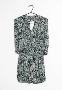 Blommig rompertopp med långärmar, svart bakgrund och mönster av ljusblå och vita blommor. Har en nyckelhålsöppning vid halsen och elastisk midja.