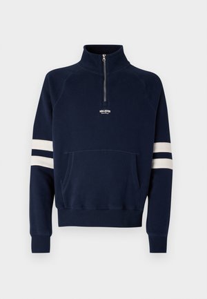 Navy sweatshirt with a half-zip collar, kangaroo pocket, and white stripes on sleeves. Made of soft fabric; features embroidered logo.