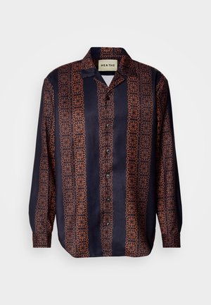 Marineblå skjorte med knapper og et blomstret geometrisk mønster i nuancer af orange. Har en krave og lange ærmer med knapmanchetter.