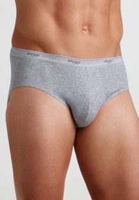 Slip grigio in cotone con una texture morbida, dotato di un cinturino elastico piatto con il branding "sloggi". Vestibilità classica e silhouette liscia.