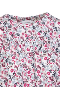 Bloes met bloemenpatroon, bestaande uit een witte achtergrond met roze, blauwe en marineblauwe bloemen. Knopsluiting en zachte stof met een geplooid ontwerp.