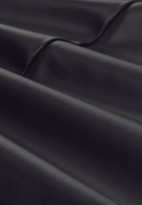 Schwarzer Kunstlederstoff mit strukturierten Oberflächen, der weiche Falten und einen leichten Glanz aufweist. Geeignet für Polsterungen oder Modeanwendungen.