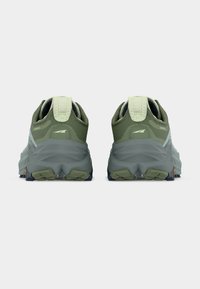 Paire de chaussures de sport vert olive et grises vues de dos sur un fond blanc, avec des semelles intermédiaires texturées et des languettes de maintien.