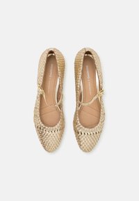 Bailarinas trenzadas de oro con puntera redondeada, correa ajustable y forro interior suave. Exterior texturizado con un patrón de trenzado detallado.