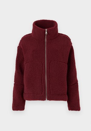 Chaqueta de forro polar burdeos con alto cuello, cierre frontal, mangas largas y dos grandes bolsillos frontales, expuesta sobre un fondo sencillo.