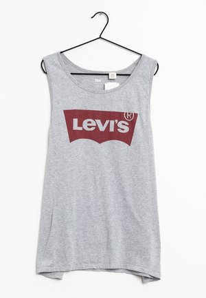 Jasnoszary bezrękawnik na ramiączkach z czerwonym logo Levi's, zawieszony na czarnym wieszaku na białym tle.