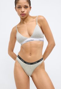 Ανοιχτό γκρι βαμβακερό σουτιέν με λεπτές τιράντες και λευκή λωρίδα με λογότυπο. Συνδυαστικό γκρι ριγέ στρινγκ με μαύρη λωρίδα μέσης με λογότυπο.